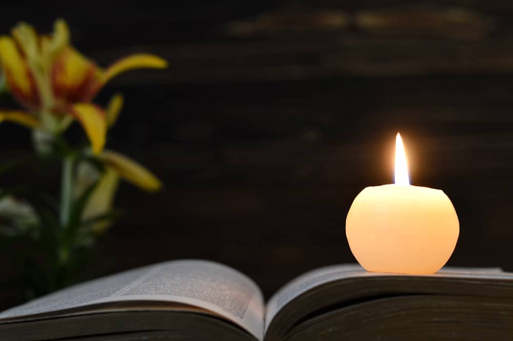 Photo of a bible and candle at a funeral