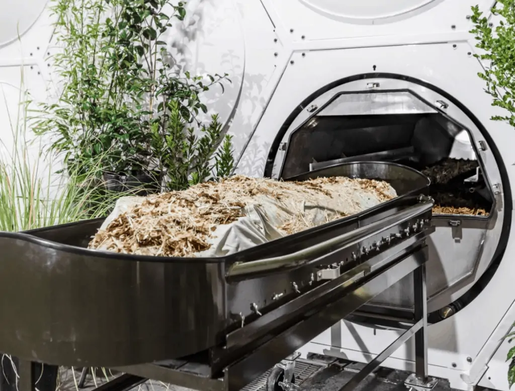 A human body with leaves and straw to be composted in a special facility that uses oxygen and heat to accelerate natural processes.